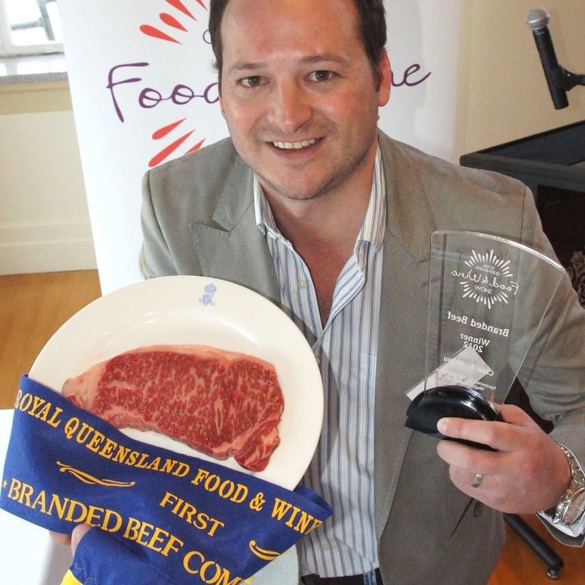 Export manager Jeremy Stuart with Andrews Meats grand champion of show.