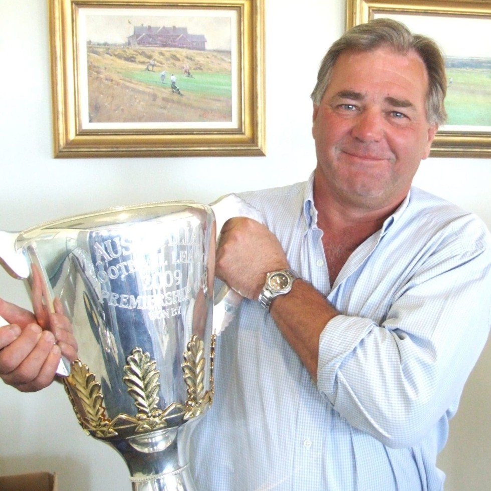 An avid Geelong AFL supporter, Frank Herd is pictured with the Club's 2011 Premiership trophy