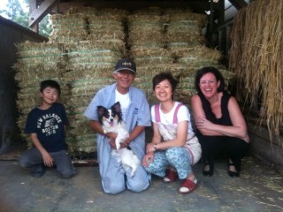 MLA Japan region manager Melanie Brock with a cattle farmer and his family receiving Australian hay in Fukushima Prefecture