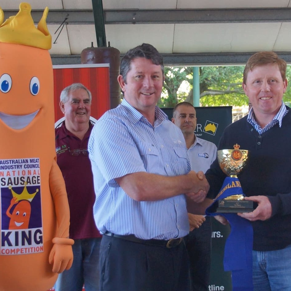 Warwick butcher Paul Carey, right, is congratulated by MLA's Glen Burke after he won the Sausage Kings beef division state final 