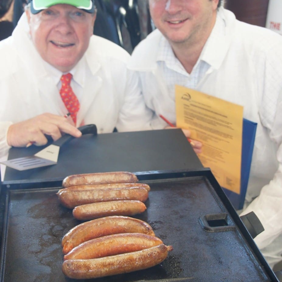 Judges Angus Adnam, left, and Glen Burke eye off the seven regional finalists competing in the Sausage Kings Queensland final yesterday.