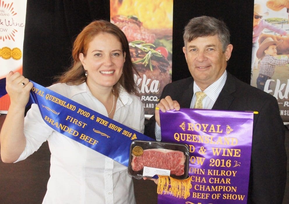 AA Co's Sabina Kindler and collects the grand champion branded beef exhibit trophy from RNA beef cattle committee chair, Gary Noller